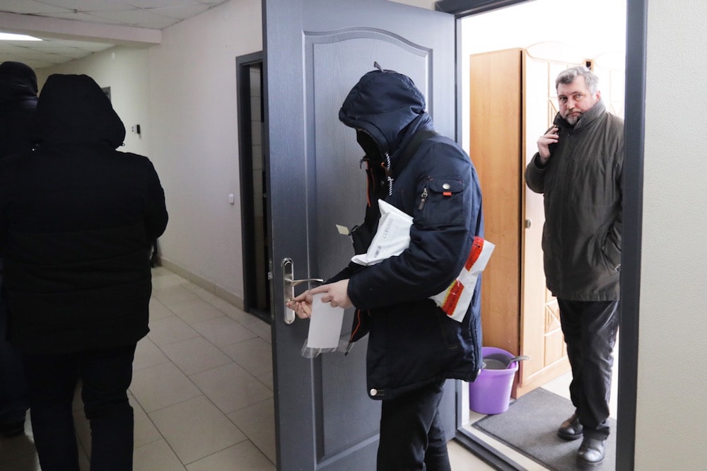 The chair of the Belarusian Association of Journalists (BAJ) Andrei Bastunets (R) and police officers leave the BAJ office after a raid by the Investigation Committee, Minsk, Belarus, 16 February 2021, -/AFP via Getty Images