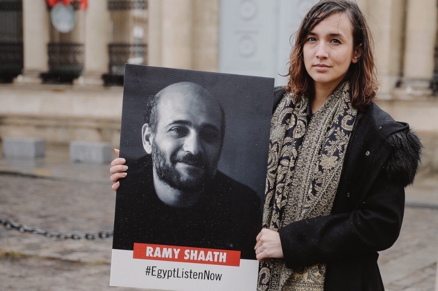 Céline Lebrun Shaath, prominent human rights defender and wife of arbitrary imprisoned Palestinian-Egyptian human rights defender Ramy Shaath, with a poster calling for his release. Free Ramy Shaath, https://www.freeramyshaath.com/