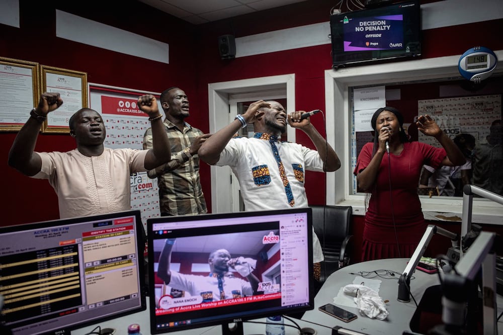 People sing during a worship radio show at Accra FM station in Accra, Ghana, 26 April 2021; MFWA was seeking information on the radio stations shut down by the NCA. CRISTINA ALDEHUELA/AFP via Getty Images