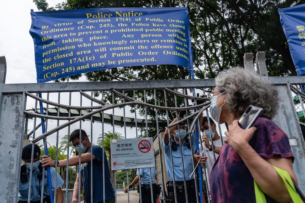 Police officers put up notices as they patrol Victoria Park, after closing the venue where people in Hong Kong traditionally gather annually to mourn the victims of the Tiananmen Square crackdown, 4 June 2021, Anthony Kwan/Getty Images