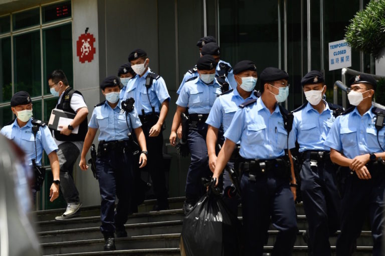 Police officers carrying files and materials for evidence walk out of the headquarters of the "Apple Daily" newspaper, in Hong Kong, 17 June 2021, Li Zhihua/China News Service via Getty Images