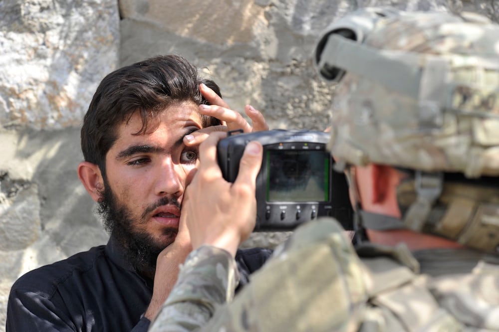 A US army soldier scans the eyes of an Afghan resident with an Automated Biometric Identification System, during a mission at Turkham, Afghanistan, 6 October 2011, TAUSEEF MUSTAFA/AFP via Getty Images