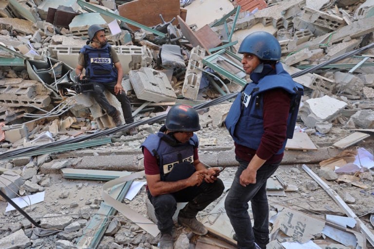 Journalists sit on the rubble of the al-Jalaa Tower, which housed international press offices, following an Israeli airstrike in the Gaza Strip 15 May 2021, MOHAMMED ABED/AFP via Getty Images