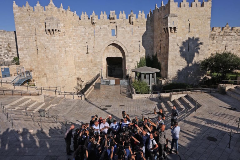 Journalists gather around two Arab-Israeli MPs (Knesset members) outside Damascus Gate in Jerusalem's Old City, 15 June 2021, ahead of an Israeli ultranationalist march, MENAHEM KAHANA/AFP via Getty Images