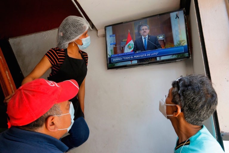 Empleados en una cafetería miran la tele, en Lima, Perú, el 15 de noviembre de 2020, LUKA GONZALES/AFP via Getty Images