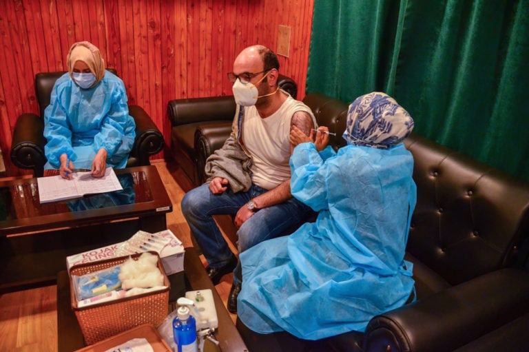 A health worker vaccinates a journalist to protect him against Covid-19, during a vaccination drive in Srinagar, India, 27 April 2021, Saqib Majeed/SOPA Images/LightRocket via Getty Images