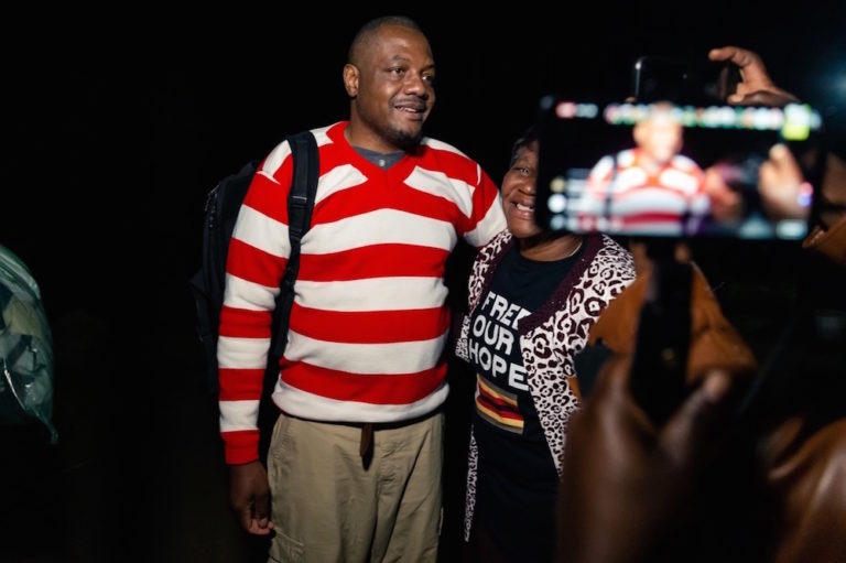 Zimbabwean journalist Hopewell Chin'ono is embraced by a supporter after his release on bail from a maximum security prison, in Harare, 2 September 2020, JEKESAI NJIKIZANA/AFP via Getty Images