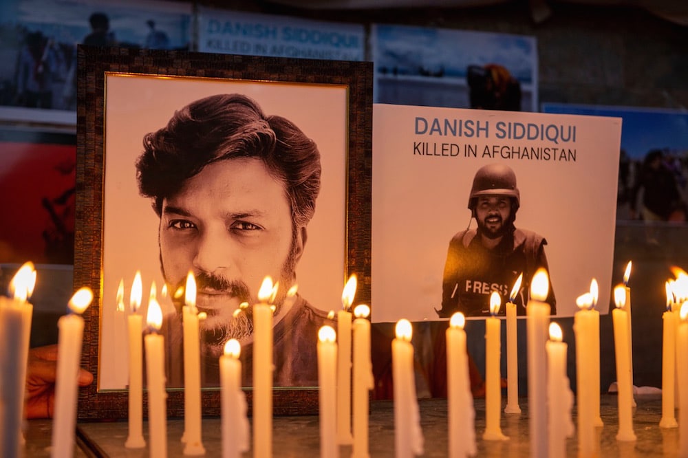 Lit candles are placed next to portraits of photojournalist Danish Siddiqui, during a vigil by the Press Club India (PCI) and the working news cameraman association (YWCA), New Delhi, India, 17 July 2021, Pradeep Gaur/SOPA Images/LightRocket via Getty Images