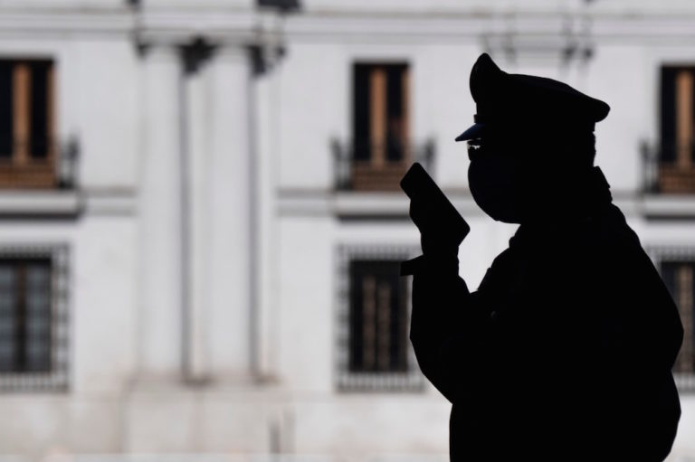 Un oficial de policía habla por teléfono, afuera del Palacio de La Moneda, en Santiago, Chile, el 13 de mayo de 2020, MARTIN BERNETTI/AFP via Getty Images