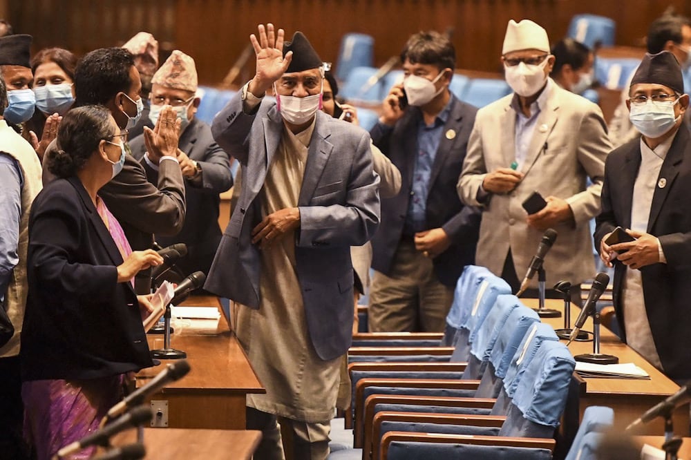 Nepal's newly appointed Prime Minister Sher Bahadur Deuba (C) waves to journalists after winning a vote of confidence in Kathmandu, 18 July 2021, PRAKASH MATHEMA/AFP via Getty Images