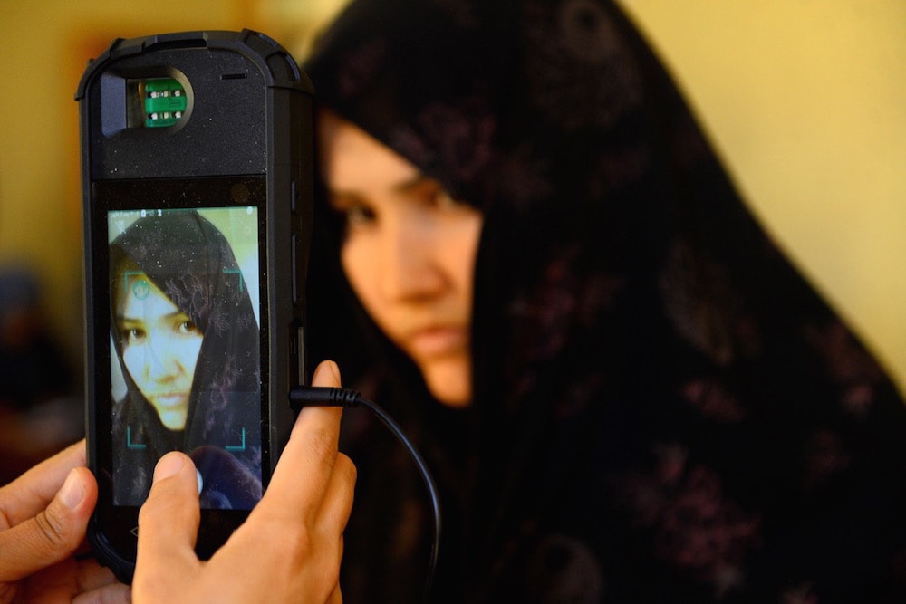 An Afghan Independent Election Commission (IEC) official scans a voter's face with a biometric device at a polling centre for the country's legislative election, in Herat province, 20 October 2018, HOSHANG HASHIMI/AFP via Getty Images