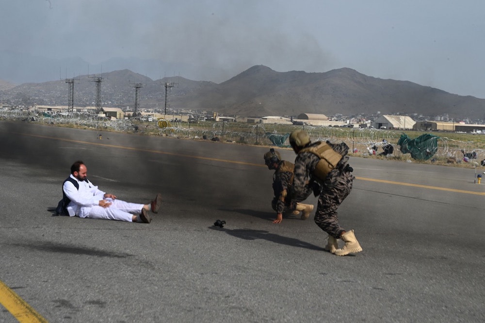 Kabul, Afghanistan, 31 August 2021. Taliban special force fighters (R) and a journalist get up after falling from a vehicle at the airport, after the withdrawal of US troops from the country, WAKIL KOHSAR/AFP via Getty Images