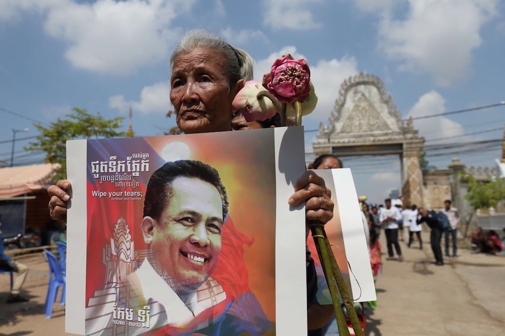 A Boeng Kak community land rights activist holds a photograph of prominent political analyst Kem Ley as she heads to his funeral ceremony, in Phnom Penh, Cambodia, 18 July 2016, Satoshi Takahashi/LightRocket via Getty Images