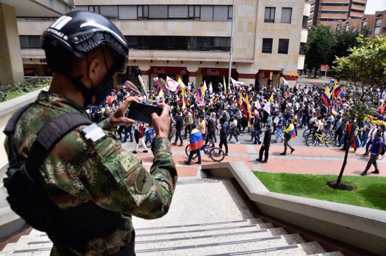 Un soldado filma unos manifestantes con su teléfono durante el Paro Nacional, en Bogotá, Colombia, el 5 de mayo de 2021, Guillermo Legaria/Getty Images