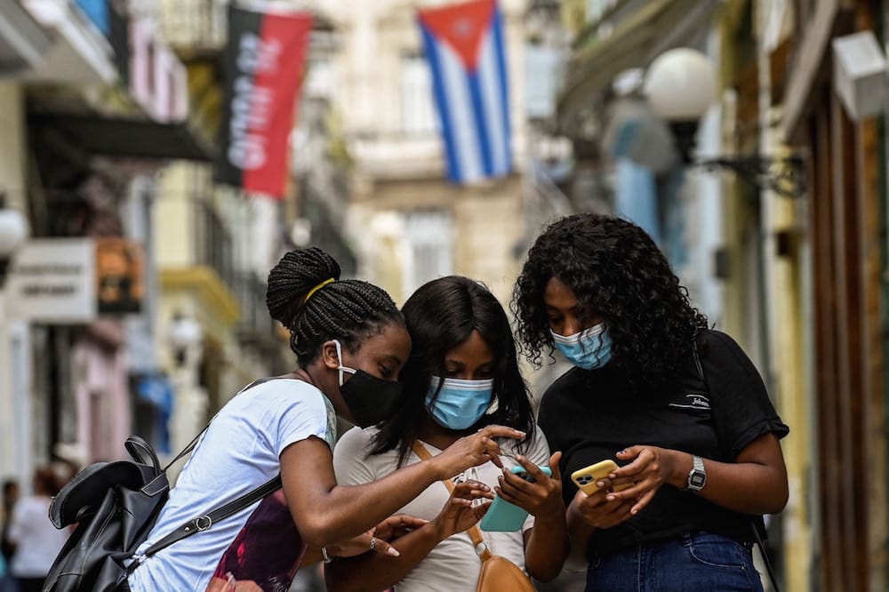 Women use their phones in a street in Havana, Cuba, 14 July 2021, YAMIL LAGE/AFP via Getty Images
