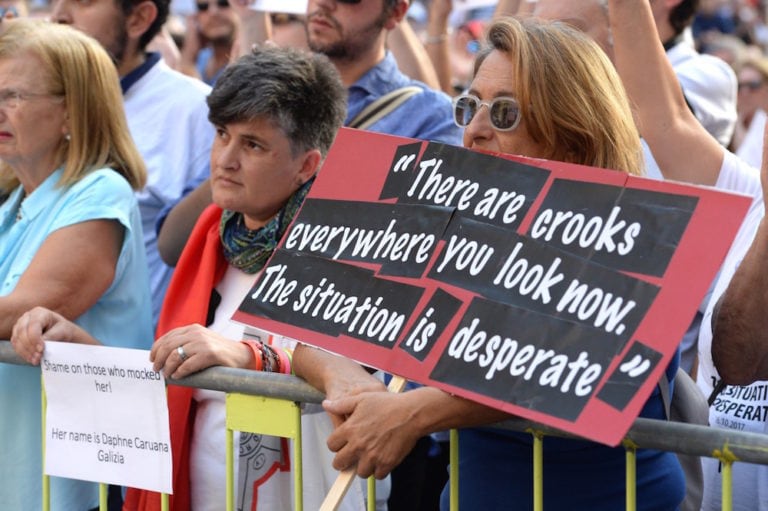 امرأة تحمل لافتة عليها اقتباس عن الصحفية المالطية المقتولة، والمدونة المناهضة للفساد، دافني كاروانا غاليزيا، خلال مسيرة للمطالبة بالعدالة على اغتيالها، في فاليتا، مالطا، 22 تشرين الأول/ أكتوبر 2017، ماثيو ميرابيلي/ وكالة فرانس برس عبر جيتي إيميدجز.