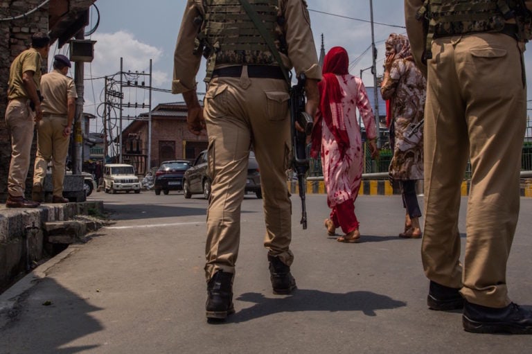 Kashmiri women walk by as Indian government forces guard the area in the old city after an explosion, in Srinagar, Indian-administered Kashmir, 5 August 2021, Yawar Nazir/Getty Images