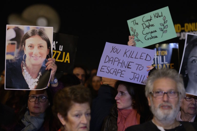Protesters hold up placards and pictures of the late journalist Daphne Caruana Galizia as they gather outside the prime minister's office in Valletta, Malta, on 20 November 2019, the day businessman Yorgen Fenech was detained after allegedly trying to flee on his yacht, MATTHEW MIRABELLI/AFP via Getty Images