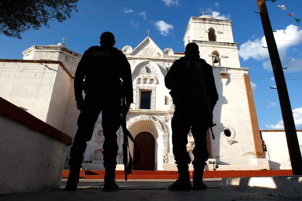 Mexican Federal Police stand guard in front of a mission church, in Tubutama, Sonora state, 6 October 2010, amid reports that cartel members were taking over the plaza at night. Don Bartletti / Los Angeles Times