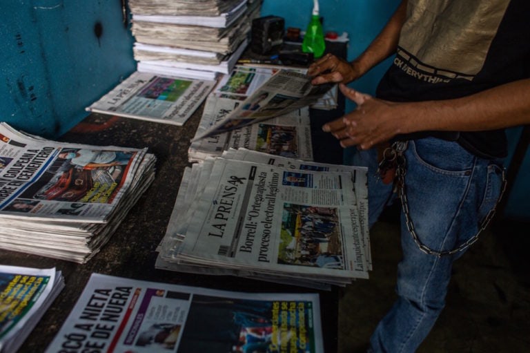 A man places copies of the newspaper "La Prensa" on a table, Nicaragua, Managua, 12 August 2021, Stringer/picture alliance via Getty Images