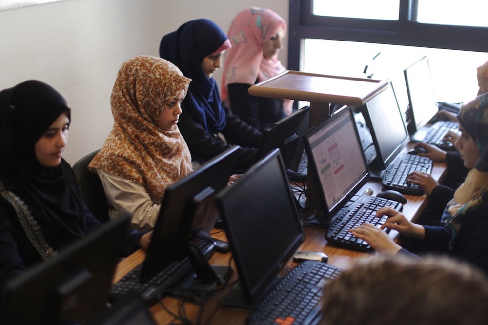 Palestinian women work on their laptops at a start up in Gaza City, 18 April 2015, MAHMUD HAMS/AFP via Getty Images