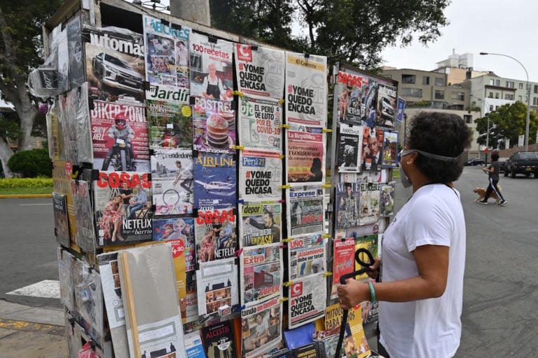 Una mujer mira a las portadas de diarios durante la pandemia Covid-19, en Lima, Perú, el 20 de marzo de 2020, CRIS BOURONCLE/AFP via Getty Images