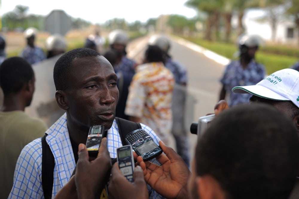 Le journaliste Ferdinand Ayité est interviewé par la presse, pendant une manifestation devant le Palais des Congrès, Lomé, Togo, le 19 février 2013, Daniel Hayduk/AFP via Getty Images