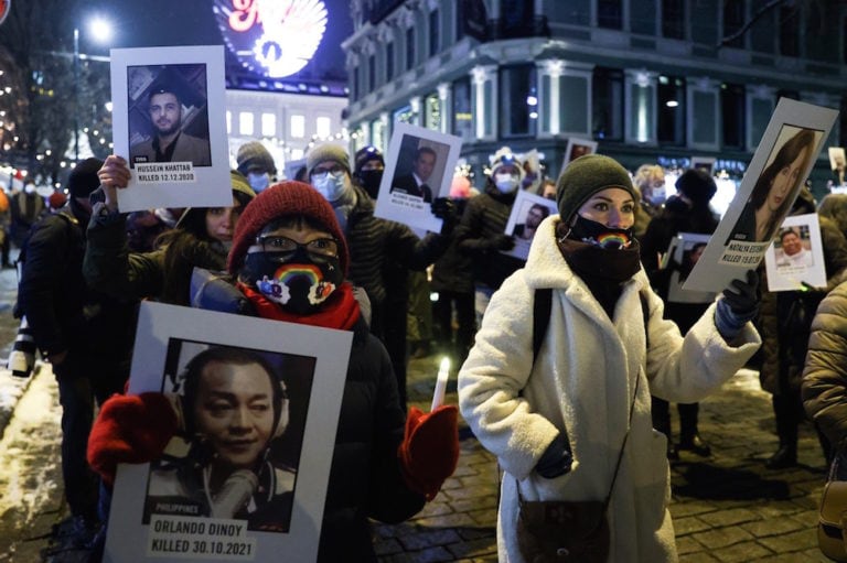 أشخاص حاملين صورًا للصحفيين القتلى، خلال مسيرة بالشعلة على شرف الفائزين بجائزة نوبل للسلام لعام 2021 من الفلبين ماريا ريسا والصحفي الروسي ديمتري موراتوف في أوسلو، النرويج
