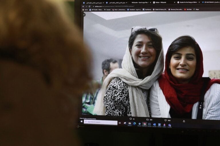 امرأة تشاهد صورة لصحفيتين إيرانيتين، نيلوفر حامدي والهه محمدي على تويتر، في نيقوسيا بقبرص، بتاريخ ٢ نوفمبر / تشرين الثاني للعام ٢٠٢٢. تصوير كرستينا عاصي من فرانس برس عبر جتي إمدجز.