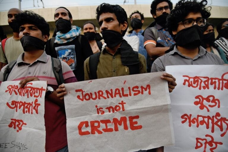 متظاهون حاملون لافتات تحمل شعار "الصحافة ليست جريمة" مطالبين بالإفراج عن مراسل يواجه اتهامات بناء على قانون بنجلاديش للأمن الرقمي. بتاريخ ٢٩ مارس / آذار للعام ٢٠٢٣ في العاصمة البنجلاديشية دكا