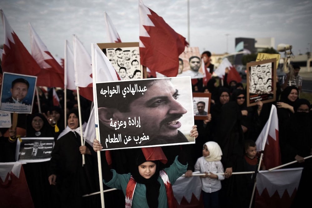 فتاة بحرينية تحمل لافتة تحمل صورة للناشط الحقوقي المسجون عبد الهادي الخواجة، خلال مظاهرة في قرية جنوسان بالبحرين. بتاريخ ٥ سبتمبر/أيلول للعام ٢٠١٤. تصوير محمد الشيخ من فرانس برس عبر جتي إمدجز.